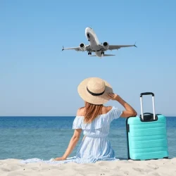 woman-suitcase-on-sandy-beach-600nw-2477287387